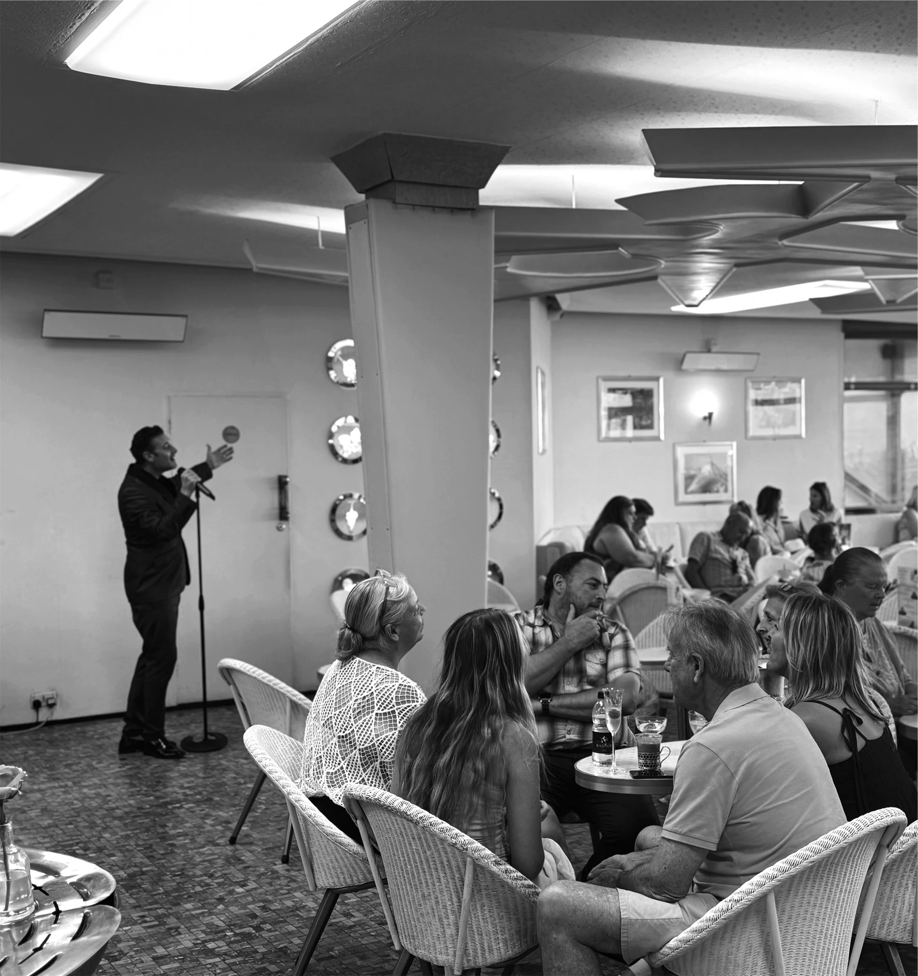 A singer performing for guests on a parlour music night